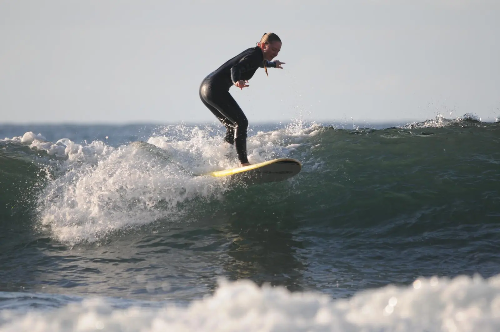 Alumna de surf cogiendo una ola
